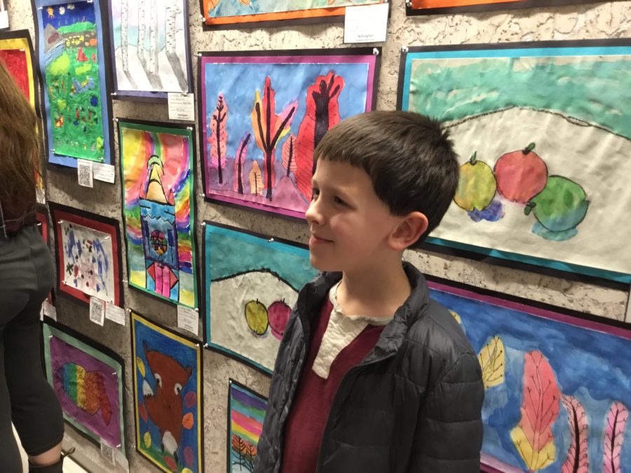 Student standing next to their artwork